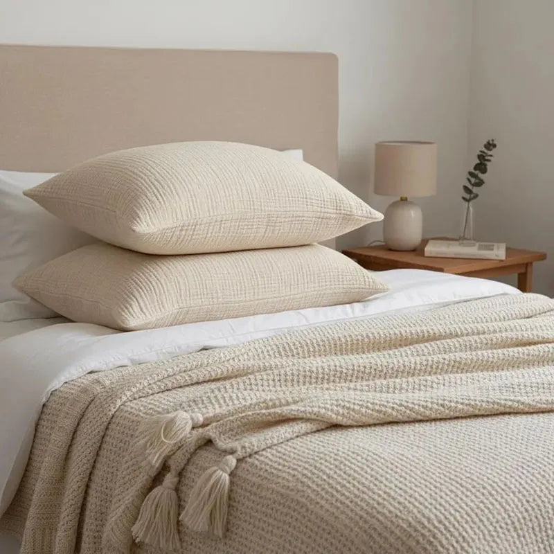 Deux taies Oniria sur un lit, dans une chambre claire