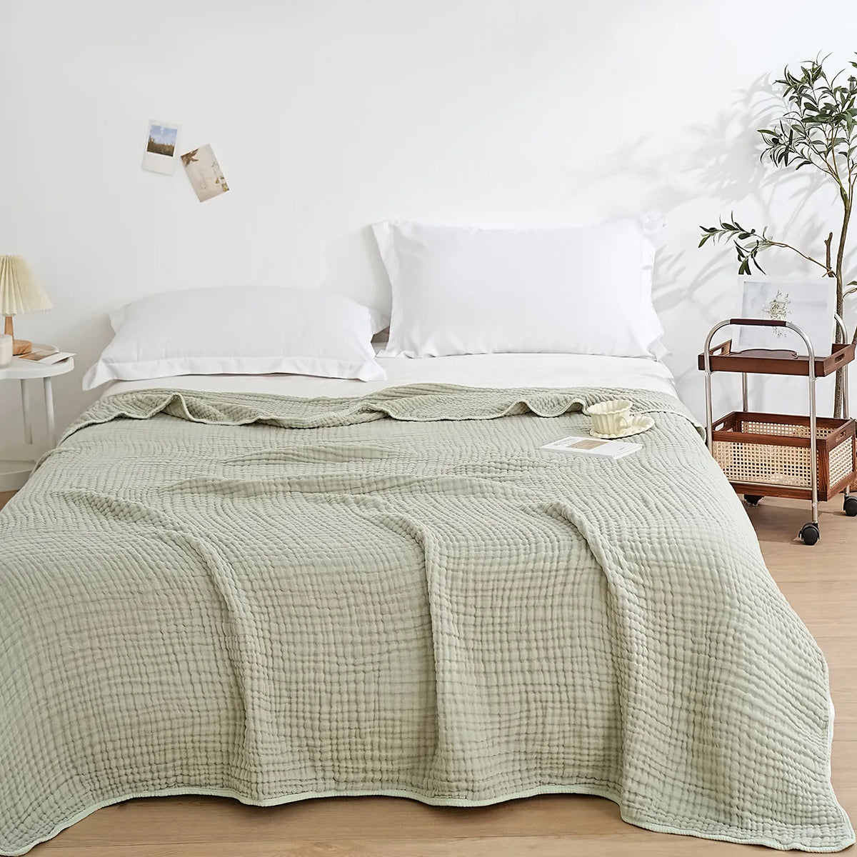 La Couverture Oniria en Olive sur un lit