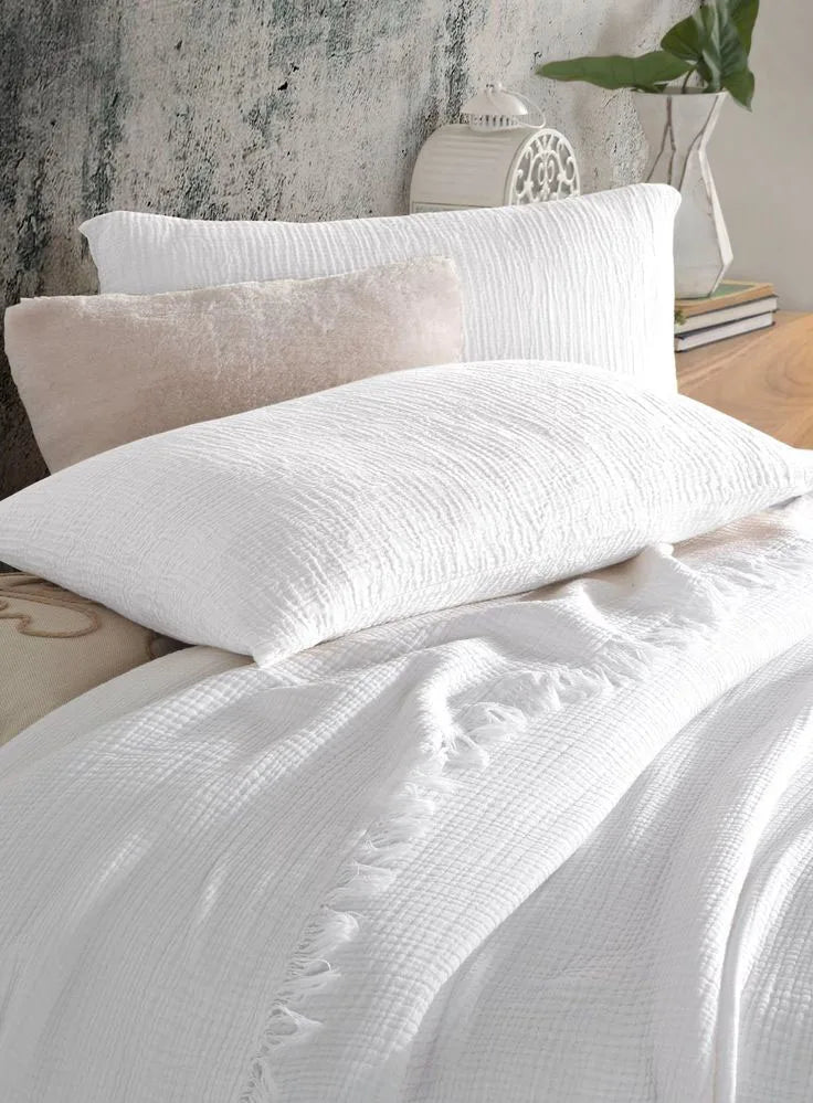 Les Taies Oniria en Nuage sur un lit blanc