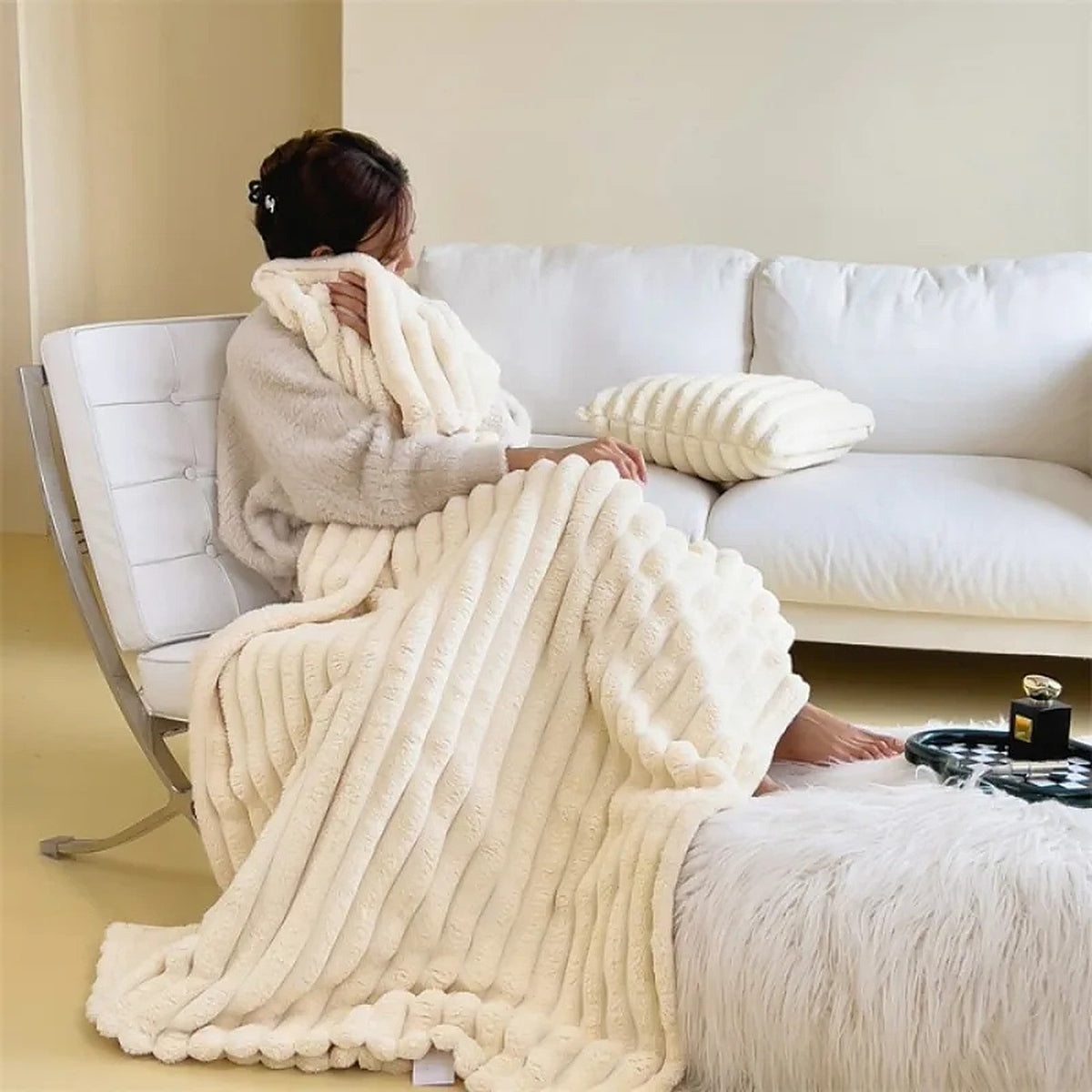 Plaid Oniria blanc crème sur un fauteuil
